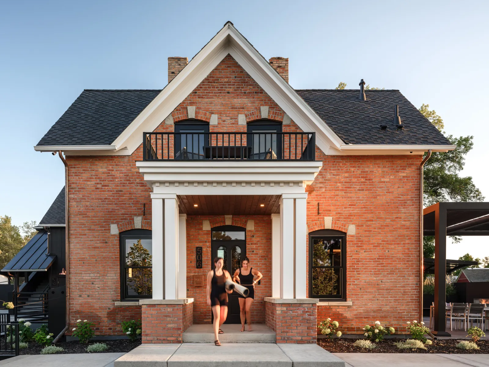 Guests stepping out of historic Rouse House with yoga mats